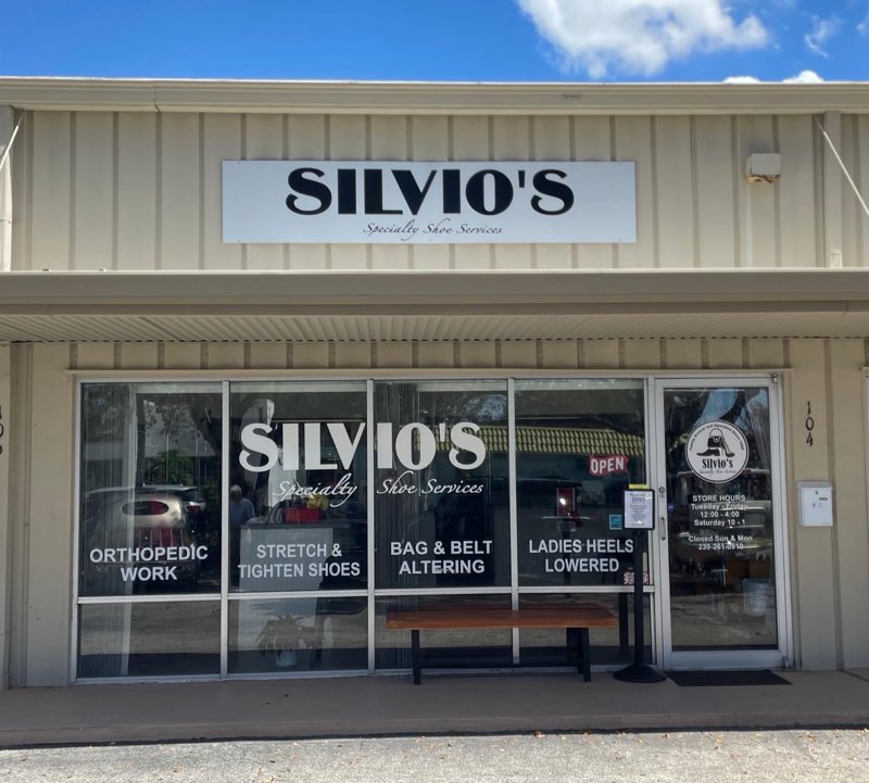 Silvio's Specialty Shoe Services storefront with window signs listing its services.